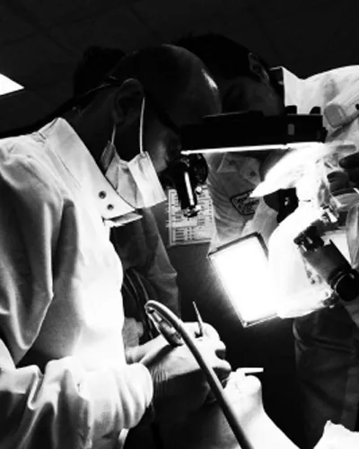 Clinicians treating a patient under the microscope